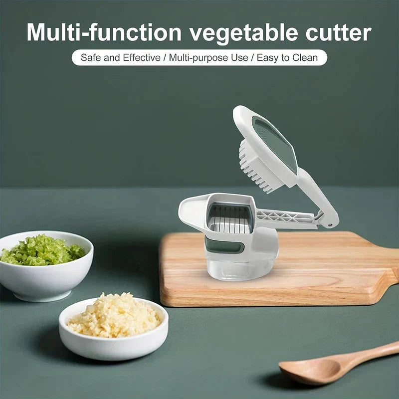 Vegetable Slicer - Open white and green vegetable cutter on wooden cutting board, with two bowls of chopped celery and minced garlic on dark green surface