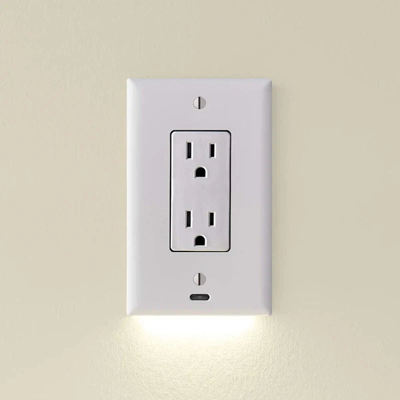 White outlet cover with integrated led night guidelight emits soft downward light, mounted on a beige wall with two electrical sockets.