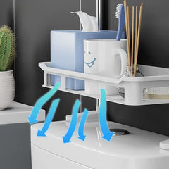 estante de almacenamiento para garaje - Estante de baño sobre un inodoro que sostiene una caja de pañuelos, un vaso con cepillo de dientes y un difusor de varillas, con flechas azules hacia abajo que indican el flujo de aire