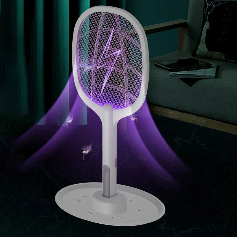Electric Fly Swatter - Pest control racket on wide base with purple light zapping insects, placed in dark living room near armchair