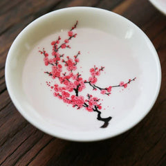 Sakura Sake Cup - White ceramic cup interior with fully visible deep red plum blossom branch design