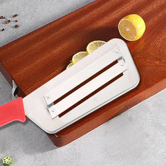 Stainless steel cabbage slicer with red handle on wooden board beside lemon slices and spices