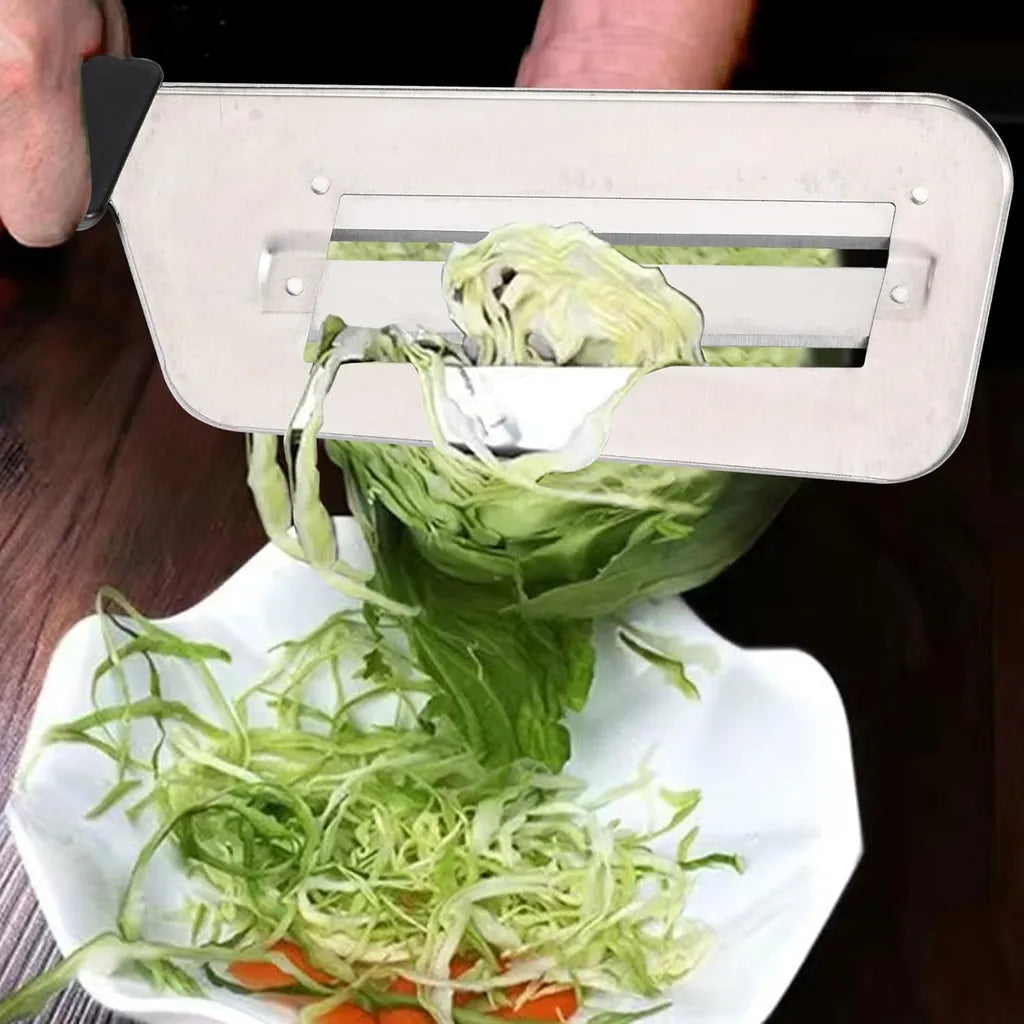 Black-handled stainless steel cabbage shredder slicing cabbage into thin strips over white bowl