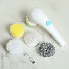 Scrubber Brush - White electric scrubber with four replaceable heads (yellow sponge, white plush, white bristle, gray steel wool style) and a USB charging cable on a marble surface