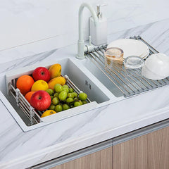 White rolling utility cart sink basket holding assorted fruit inside a kitchen double sink, with a dish rack on the adjacent basin