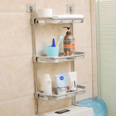 Storage Shelf Rack - Three-tier grey bathroom shelf mounted on a tiled wall above a toilet, holding toiletries and towels