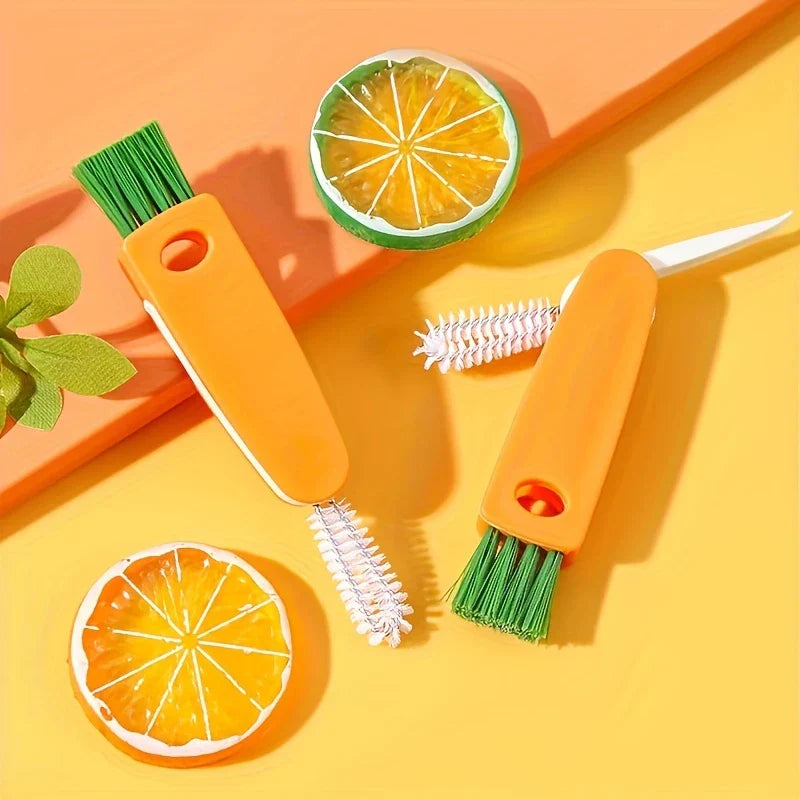 Bottle Cap Cleaning Brush Tool - Two orange 3-in-1 cleaning brushes placed on yellow-orange surface with decorative citrus slices and green leaf accent
