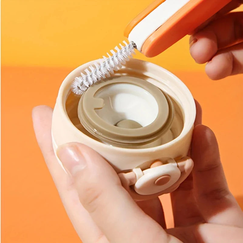 Bottle Cap Cleaning Brush Tool - A hand holds a beige cup lid, while a second hand holds an orange and white tool with a curved bristle brush near the lid's inner ring.