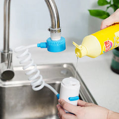 Swivel Faucet Extender - Faucet-mounted adapter with coiled hose, hand holding spray head near dish soap bottle