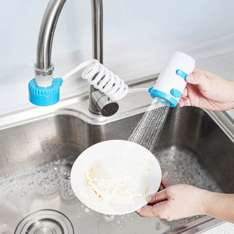 extensor de grifo giratorio - Manos sosteniendo el cabezal de ducha manual, rociando agua sobre un plato sucio sobre un fregadero de acero inoxidable