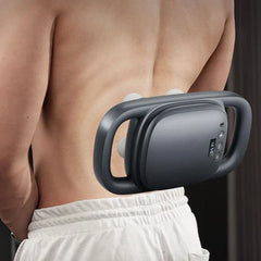 Pistola de masaje de percusión mini: espalda y torso inferior desnudos de una persona, con un masajeador manual gris oscuro con cuatro cabezales de masaje visibles sostenido contra la parte baja de la espalda.