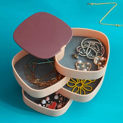 ketten organizer - Schmuckorganizer-Box - Geöffneter Drehturm mit verschiedenen Ohrringen und Armbändern auf türkisfarbenem Hintergrund