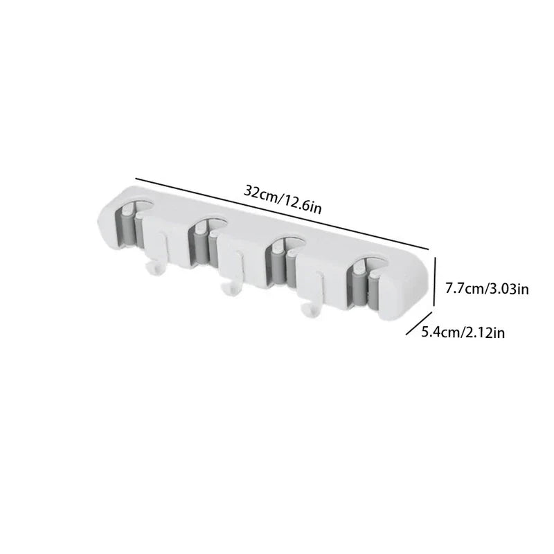 soporte de pared para trapeador y escoba - Organizador blanco de pared para trapeador y escoba con dimensiones etiquetadas de 32 cm, 7,7 cm y 5,4 cm, sobre fondo blanco