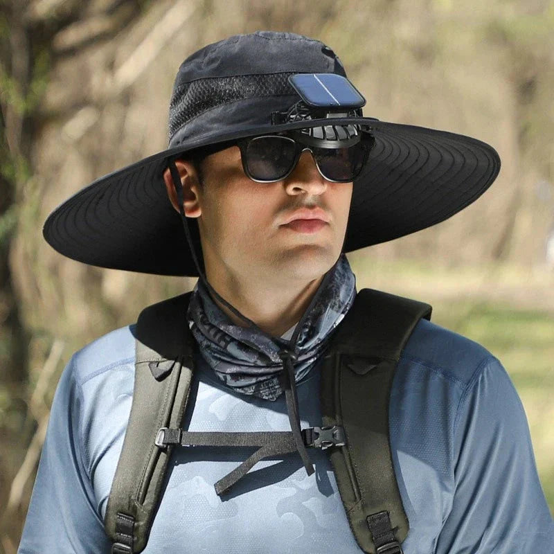 Wide Brim Sun Hat - Solid black hat with front-mounted solar fan, mesh crown panel, and adjustable chin strap, worn with hiking gear