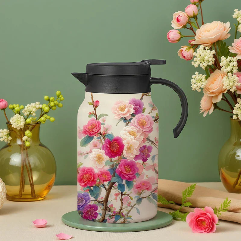 Vintage Floral Tea Thermos - Insulated carafe with pink and purple camellia floral print, black lid and handle, displayed with glass vases of flowers