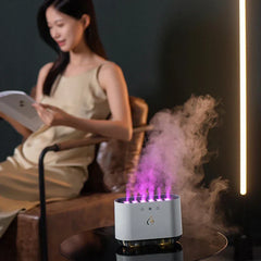 Cool Mist Humidifier - 6-nozzle unit emitting purple-lit mist on a glass table, with a person reading in the background