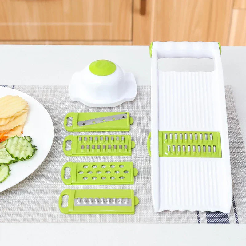 Vegetable Slicer Chopper - slicer body, food holder, and four blade inserts arranged on linen mat with plate of cut vegetables to the side