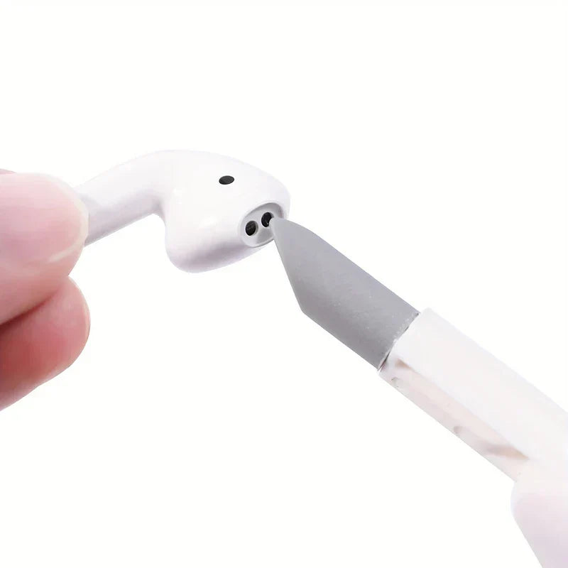 Electronics Cleaning Kit - Fingers hold a white wireless earbud while a grey pointed cleaning tool tip touches the earbud's speaker holes