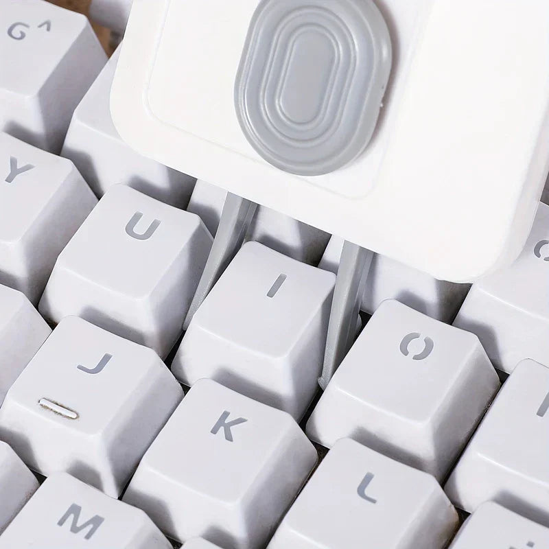 Electronics Cleaning Kit - Close-up of a white cleaning tool with two prongs inserted between white keyboard keys.