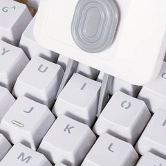 Electronics Cleaning Kit - Close-up of a white cleaning tool with two prongs inserted between white keyboard keys.