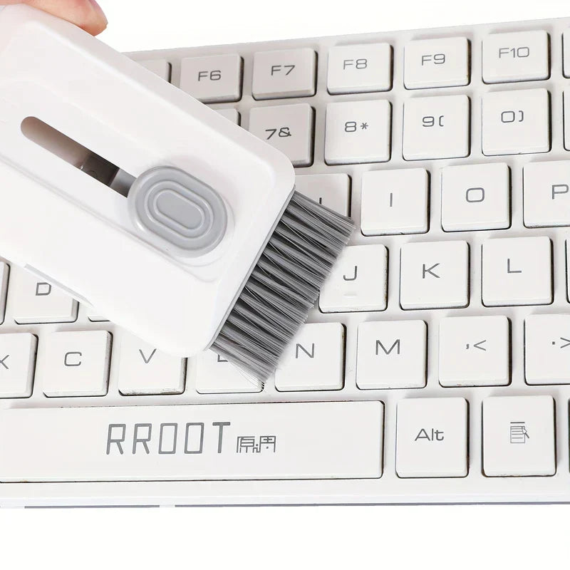 Electronics Cleaning Kit - A hand holds a white cleaning tool with a gray brush, brushing a white computer keyboard.