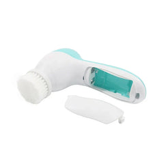 Handheld facial cleansing brush with its battery cover removed, showing the internal battery compartment