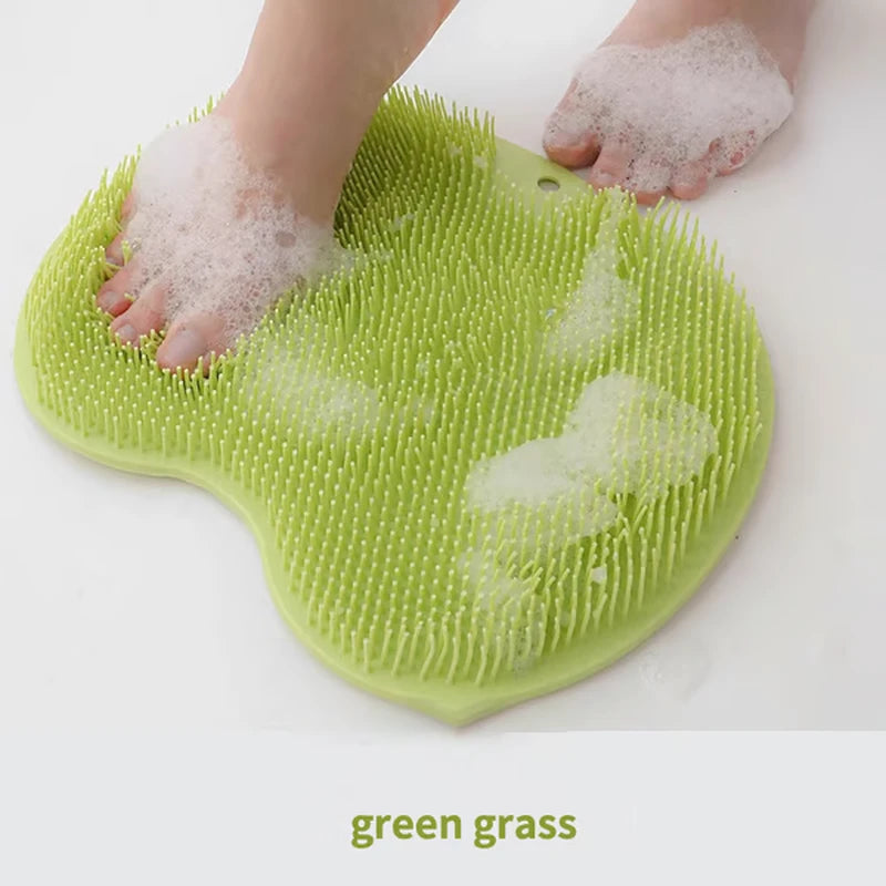 Person's soapy foot on a green grass silicone shower foot scrubber mat with foam and visible bristles