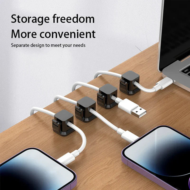 selbstklebende kabelclips für die wand - Vier Kabelhalter auf einem Holztisch organisieren Ladekabel, die mit Smartphones und einem Laptop verbunden sind