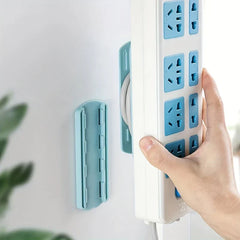 Power Strip Holder - Hand sliding a power strip onto a light blue wall-mounted plastic mount