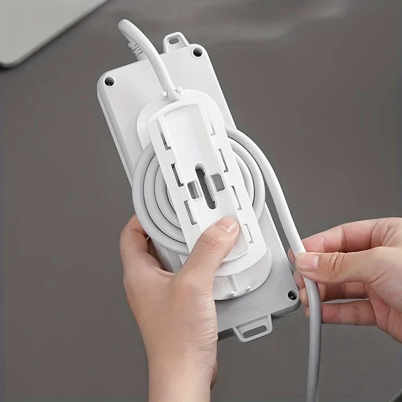 Power Strip Holder - Hands attaching white plastic mount to the back of a power strip with coiled cord