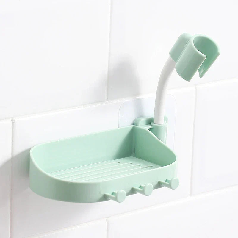 Shower Head Holder - Light green wall-mounted soap dish with hooks and a curved hose clip, attached to a white tiled wall.