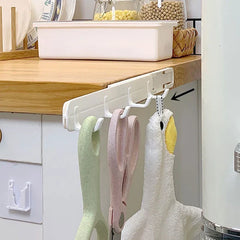Wall Hook Hanger - White hook rack attached to the underside of a wooden kitchen counter, holding a green vegetable peeler, pink scissors, and a white duck-shaped towel