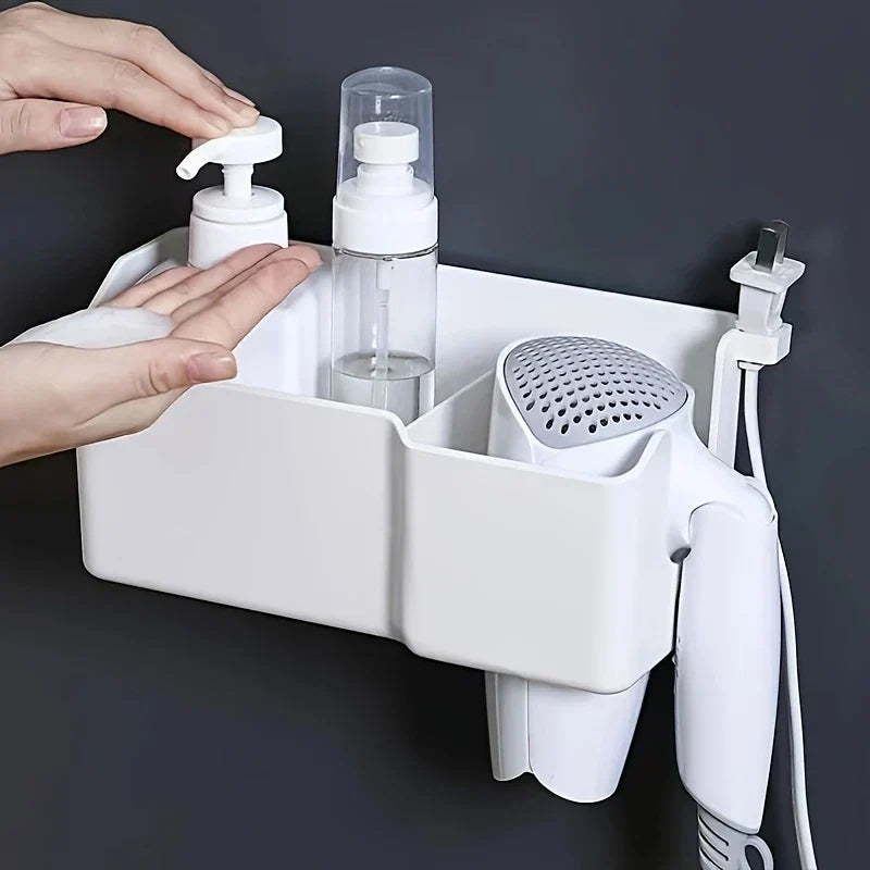 wandhalterung für haartrockner - Weißer wandmontierter Aufbewahrungskorb, der zwei Pumpspenderflaschen und einen Haartrockner hält, mit einer Hand, die eine Seifenpumpe betätigt, um Schaum auf eine Handfläche zu spenden