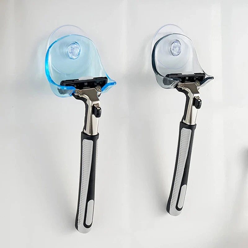 Soporte de pared adhesivo con ventosa para maquinilla de afeitar - dos ganchos de ventosa en azul y gris humo, cada uno sosteniendo una maquinilla sobre una pared blanca