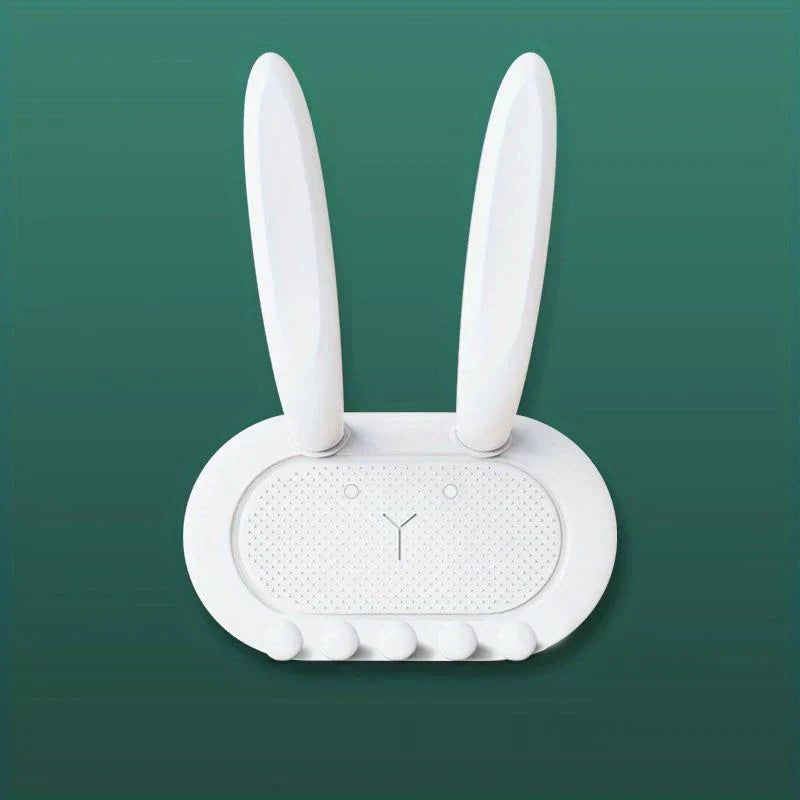 Utility Hooks - White rabbit-shaped wall organizer with long ears and five small pegs, on a solid teal background