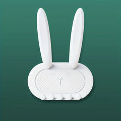 Utility Hooks - White rabbit-shaped wall organizer with long ears and five small pegs, on a solid teal background