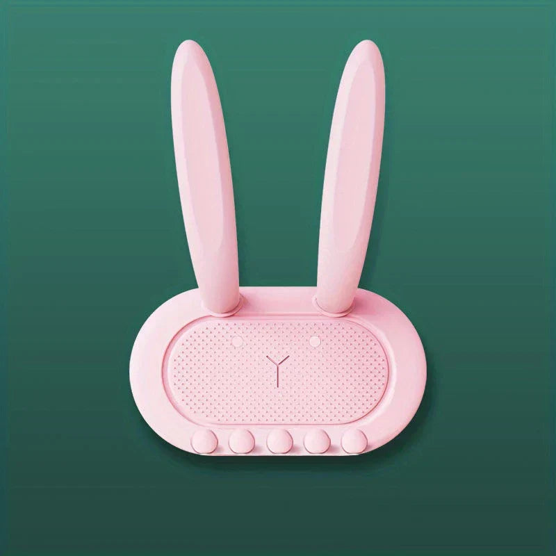 Utility Hooks - Pink rabbit-shaped organizer with long ears, dotted face, five bottom bumps, against dark green background.
