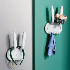 Utility Hooks - White bunny-shaped hooks mounted on walls holding headphones, towel, and hair accessories