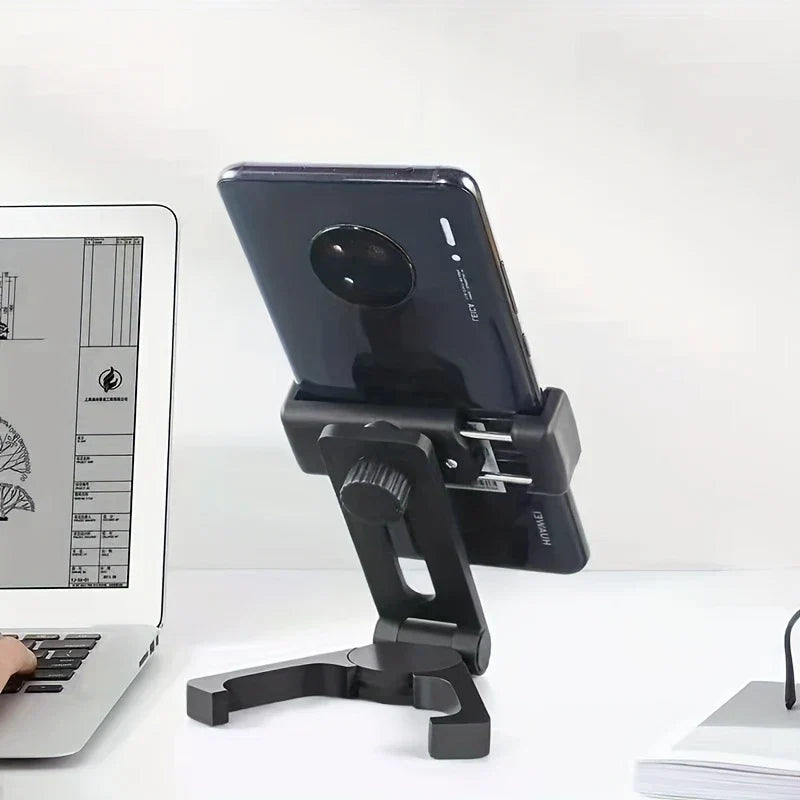 Soporte para teléfono móvil - Soporte ajustable negro sosteniendo un smartphone sobre un escritorio junto a una computadora portátil