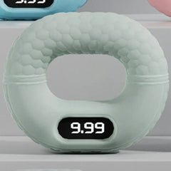 Light green digital hand grip strengthener with 9.99 displayed on its screen, on a light gray shelf.