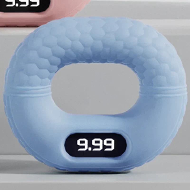Light blue digital hand grip strengthener with 9.99 displayed on its screen, on a light gray shelf.