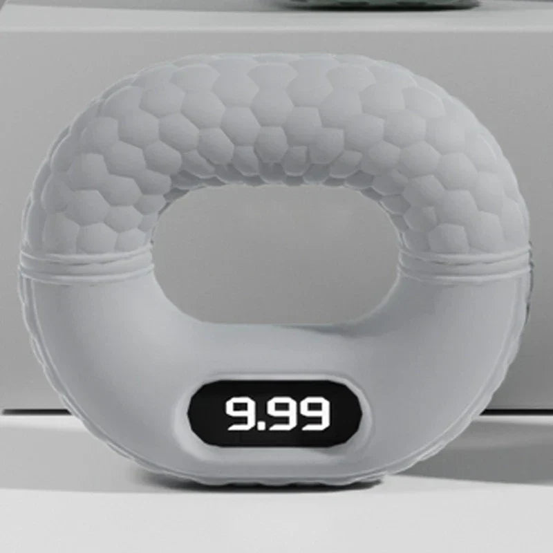 Light gray honeycomb-textured hand grip strengthener with digital display showing 9.99, on a white surface