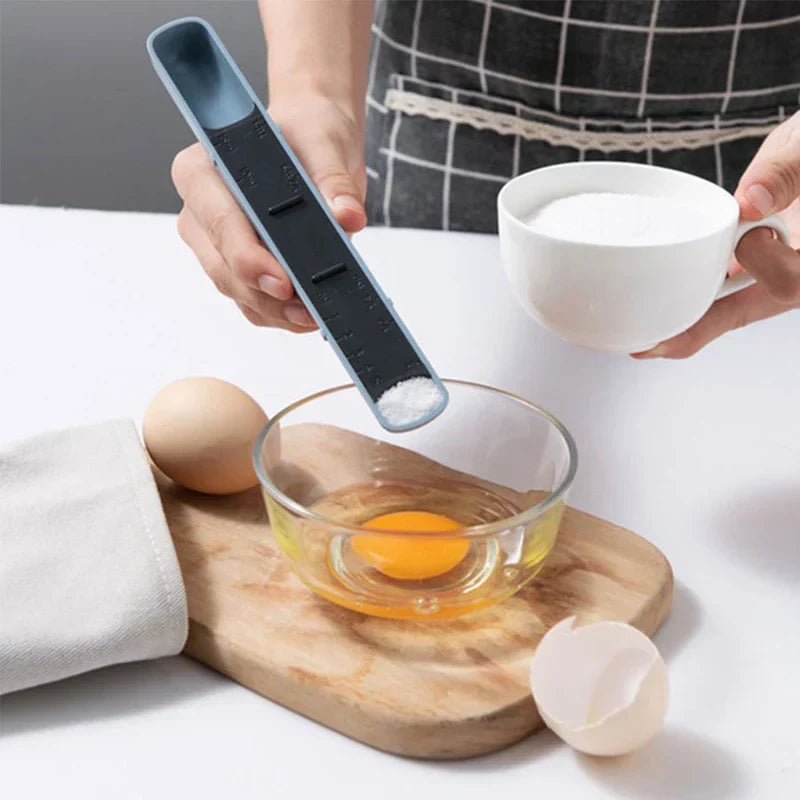 cuchara medidora ajustable - cuchara medidora con deslizador dispensando polvo blanco en un bol de vidrio con un huevo