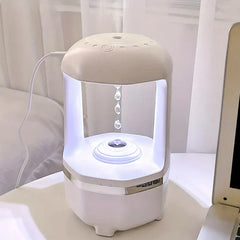 Water Drop Humidifier - white humidifier with cool white light placed on desk next to laptop