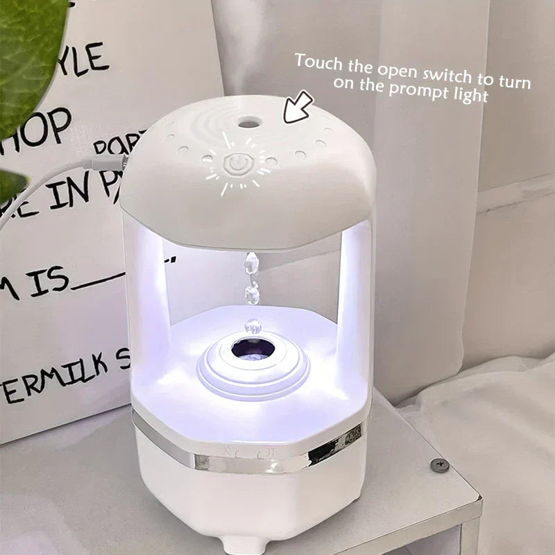 Water Drop Humidifier - White desktop device with glowing internal light shows droplets falling upward, arrow points to top touch switch with text about prompt light.