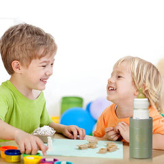 portavasos aislante para latas con base antideslizante - portavasos verde oliva sosteniendo un biberón sobre una mesa con dos niños jugando con bloques de construcción cerca