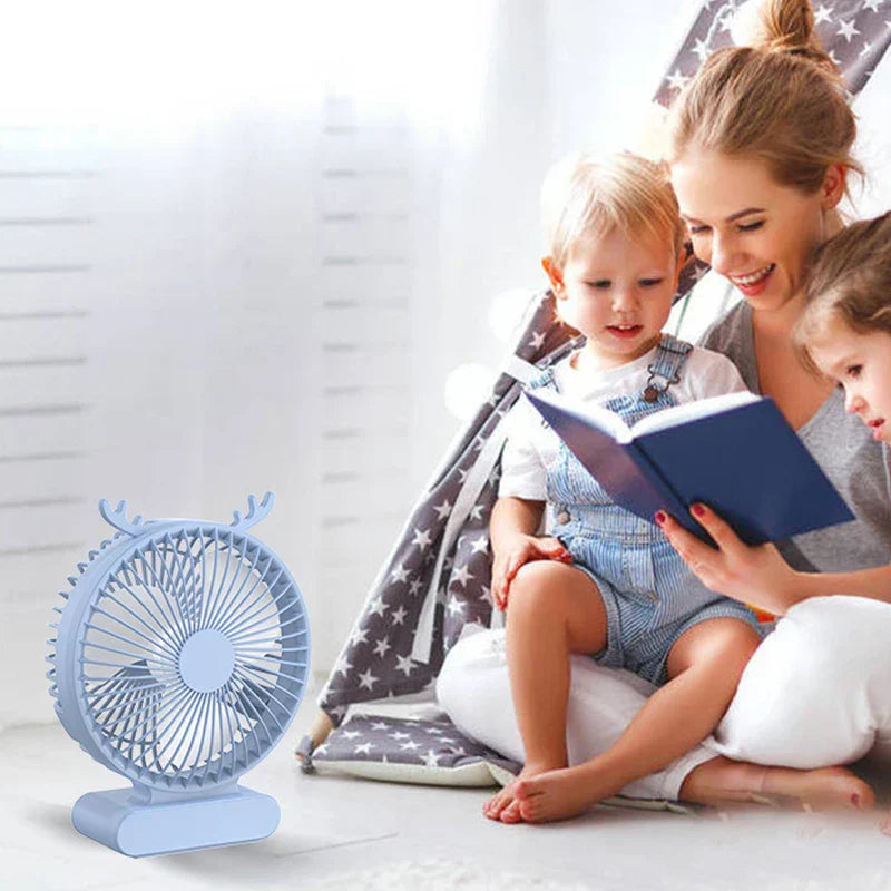 Light blue deer-antler usb desktop fan near woman reading to two children in bright room