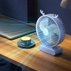 tischventilator - Hellblauer USB-Tischventilator im Geweih-Stil auf einem Holztisch, neben einer Kaffeetasse und einem Laptop in einem schwach beleuchteten Raum
