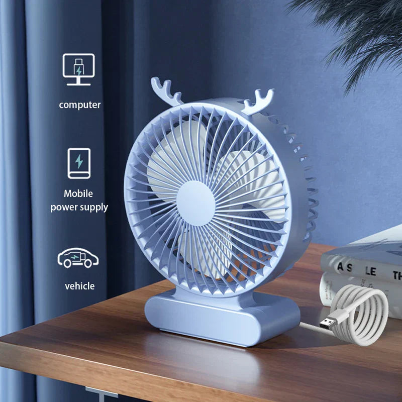 tischventilator - Hellblauer USB-Tischventilator mit Geweih-Design auf einem Holztisch, mit USB-Kabel, Büchern und Symbolen für Computer, Powerbank und Auto in der Nähe