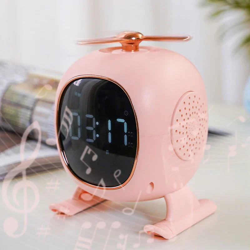 Pink helicopter-shaped bluetooth speaker with a digital clock display sits on a light-colored table
